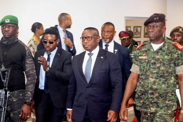 Sierra Leone's President Julius Maada Bio, who chairs ECOWAS, walks with Guinea-Bissau's transitional president Major-General Horta Inta-a during a meeting in Bissau